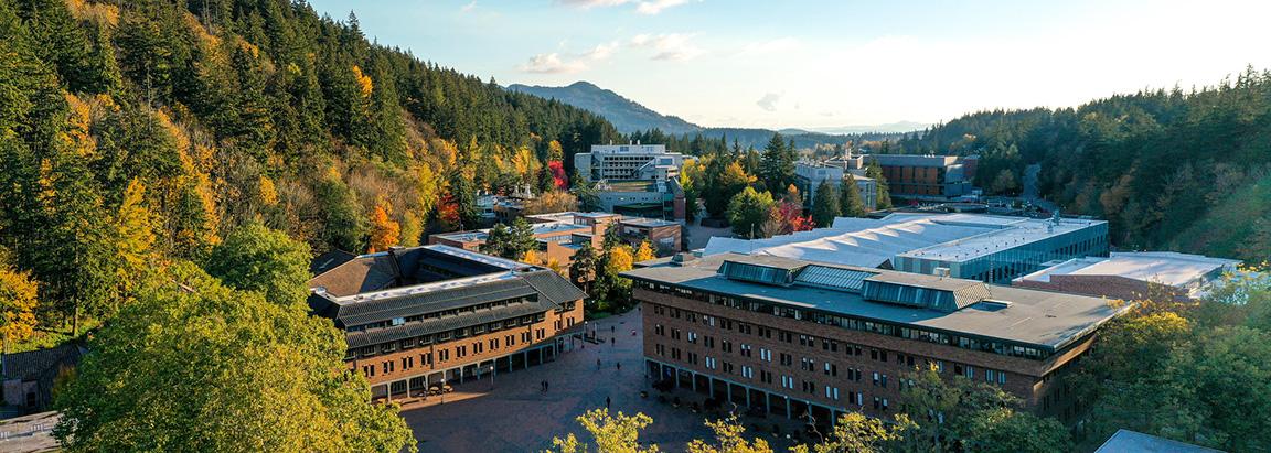 Aerial view of WWU campus on a sunny day with fall colors on the surrounding hills